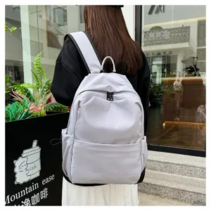 Detail view of casual solid color backpack worn outdoors, showcasing everyday fashion style.