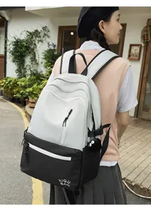 Stylish color block campus backpack for women with front zipper pocket and trendy design.