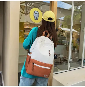 Detailed view of dual tone campus backpack with front pocket and charm design for daily use