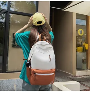 Detailed view of a stylish colorblock campus backpack with front pockets and cute hanging.