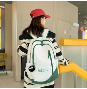 Large capacity student canvas backpack in white and green with multiple pockets and cute plush pendant.