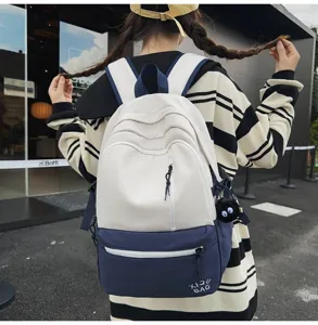 Stylish colorblock campus backpack with cute charm, casual dual shoulder bag for daily use.