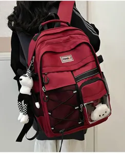 Utility style student backpack detail with transparent pocket and red durable fabric.