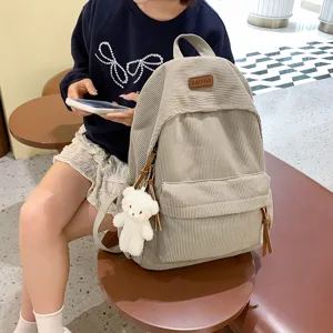 Corduroy backpack for women, casual school bookbag with cute bear pendant and large capacity.