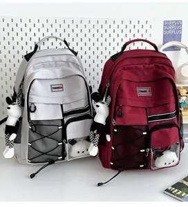 Detailed view of the multi-pocket casual school backpack featuring cute doll pendants.