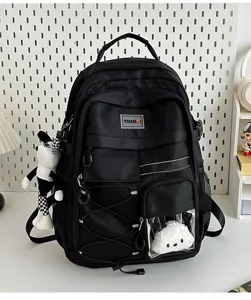 Detailed view of the black utility backpack featuring front clear pocket, straps, and cute doll.