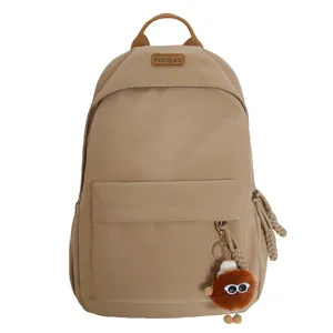 Casual khaki school backpack for teenage girls with cute plush keychain and spacious compartments.