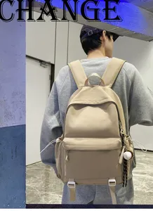 Classic solid color large capacity canvas backpack with side pockets and baseball pendant for daily use.