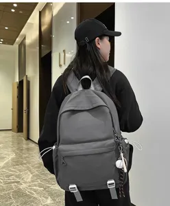 Detailed view of dark grey casual backpack in indoor setting, showing side drawstring features.