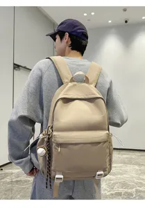 Detailed shot of casual khaki canvas backpack with multiple pockets and shoulder wear look.