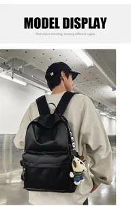 Black PU leather backpack detail view showing soft texture, spacious capacity and cute dog pendant.
