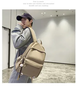 Detailed shot of a stylish khaki backpack worn by a model in a modern indoor scene setting.
