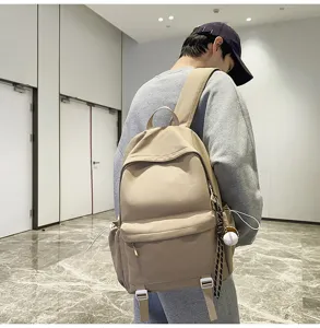 Casual khaki backpack detail view, modern school bag showing side pockets and straps.