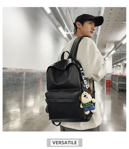 Detail view of stylish black PU leather backpack with cute dog pendant and spacious main compartment.