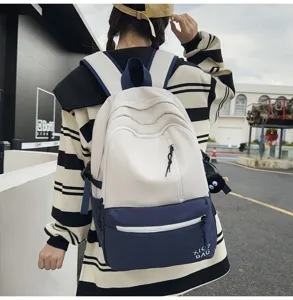 Detailed view of color block campus backpack with multiple zip pockets, casual student design.