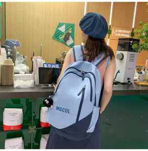 Detailed shot of the blue school backpack with multiple compartments in a cozy cafe scene.
