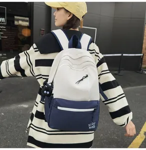 Detail view of a stylish color-blocked campus backpack with front zipper pocket and adjustable straps.