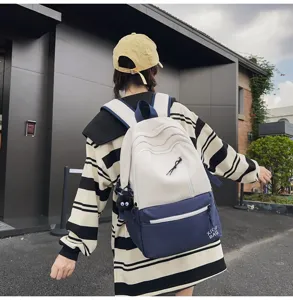 Two-tone canvas backpack for women and students with contrast color design and front pocket.