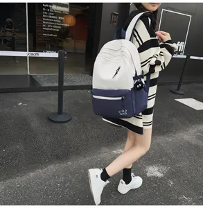 Street view detail showing the stylish color-blocked canvas backpack in white and navy blue.