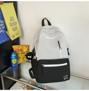 Detail view of the two-tone canvas backpack featuring convenient front zip pockets and style.