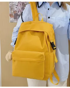 Solid yellow nylon backpack detail view, casual school bag with multiple pockets and secure buckles.