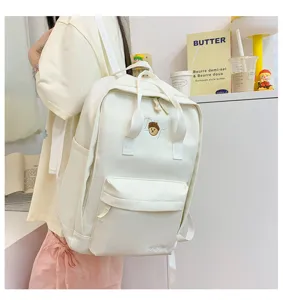 Casual white canvas backpack for women, stylish school bag with front pocket for daily use.
