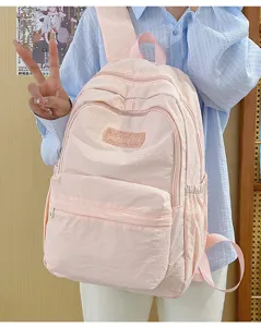 Pink nylon casual backpack detail view showing lightweight design for students use.