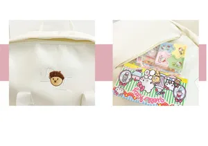 Close-up detail of white campus backpack with cute embroidery and accessories inside.