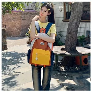 Outdoor detail shot of a colorful kids backpack worn by model, featuring multi-color block design.