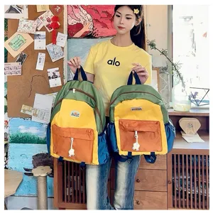 Colorful kids colorblock backpack with front pocket and cute charm for school daily use.
