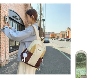Detail view of stylish waterproof casual backpack with contrasting colors and cute plush pendant.