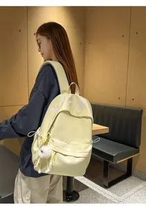 Close-up detail shot of the casual light yellow backpack worn by model, showcasing texture and style.