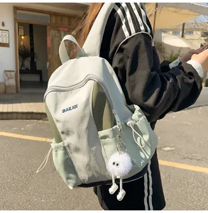 Detail view of the lightweight casual travel backpack with cute plush charm and pockets.