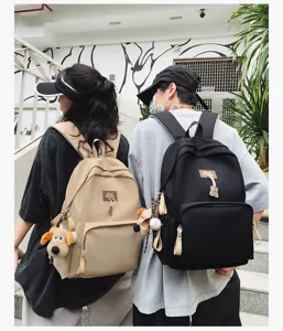 Casual canvas campus backpack large capacity student school bag with cute plush pendant for daily commute.