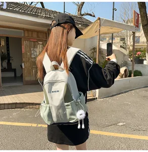 Detail view of lightweight casual backpack with side pockets, cute charm and dual straps.