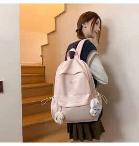 Casual pink campus backpack for teen girls, lightweight school bag with cute plush pendants.