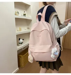 Casual pink campus backpack for daily use, lightweight school bag with cute plush charms.