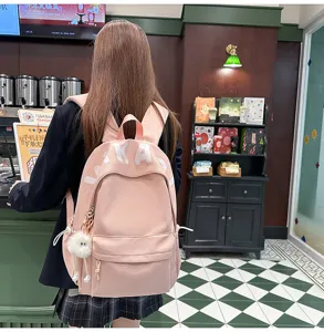Japanese style large capacity pink backpack detail view with cute plush charm and letter print.