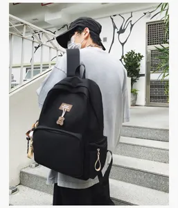 Detailed view of the black canvas casual campus backpack with front pocket and cute bear.