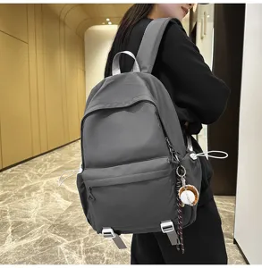 Detail view of casual dark grey backpack worn by model, showcasing large capacity and sleek design.