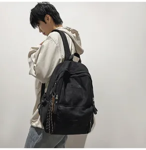 Detailed side view of a black casual campus backpack worn by a model, large capacity.