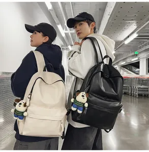Detail view of stylish PU leather backpack in black and white worn by models outdoors.