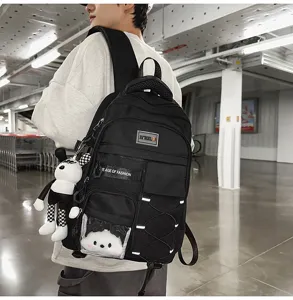 Detailed view of a multi-functional black school backpack with large capacity and cute pendant.