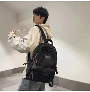 Detail shot of a black minimalist canvas backpack worn by model, showing large capacity.