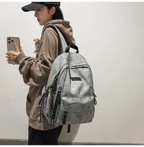 Detailed side view of the grey tie-dye canvas school backpack with practical front pockets.