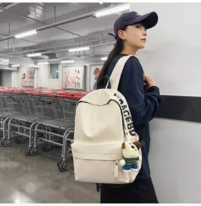 Waterproof PU leather backpack for women, minimalist student school bag with cute pendant.