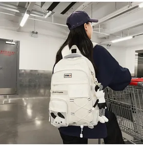 White canvas backpack for students, large capacity school bag with cute doll and multi pockets.