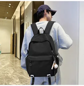 Detailed view of a black casual backpack showing durable fabric and functional zipper compartments.