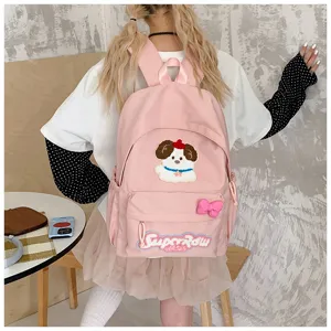 Detail shot of cute pink school backpack featuring adorable puppy patch and bow decoration.