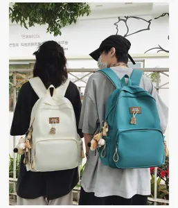 Outdoor lifestyle detail view showcasing trendy campus backpacks with cute bear pendants and patches.